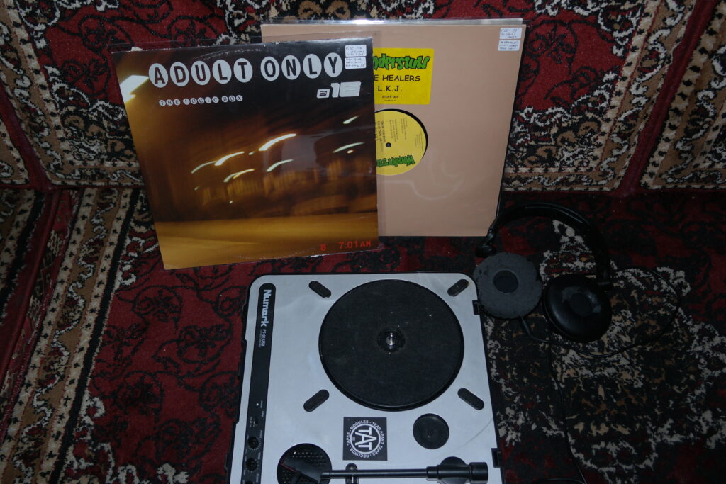 Vinylspeler met een plaat en een koptelefoon ernaast, klaar om muziek af te spelen.